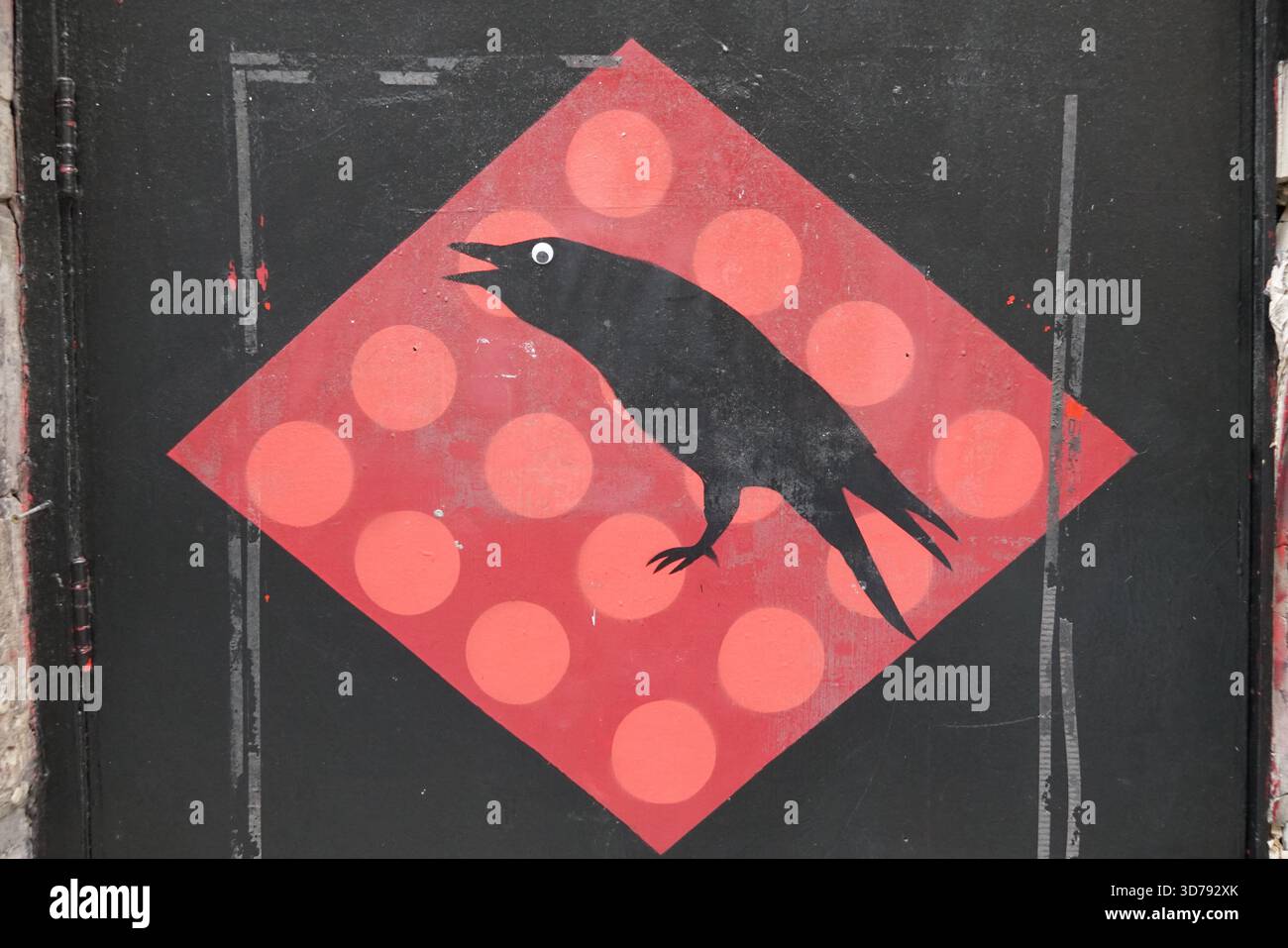 Murale di Street art di un corvo nero stilizzato dipinto su uno sfondo geometrico a pois rosso. Edimburgo, Scozia Foto Stock