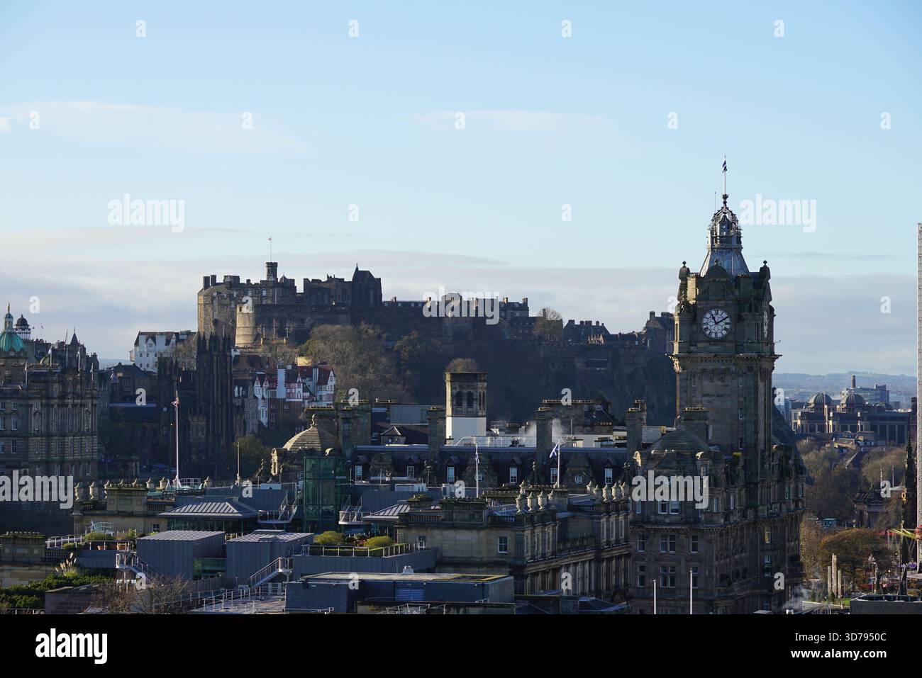 Vista del Castello di Edimburgo e della Torre dell'Orologio Balmoral che si innalza sopra la città sotto la luce del sole. Edimburgo, Scozia Foto Stock