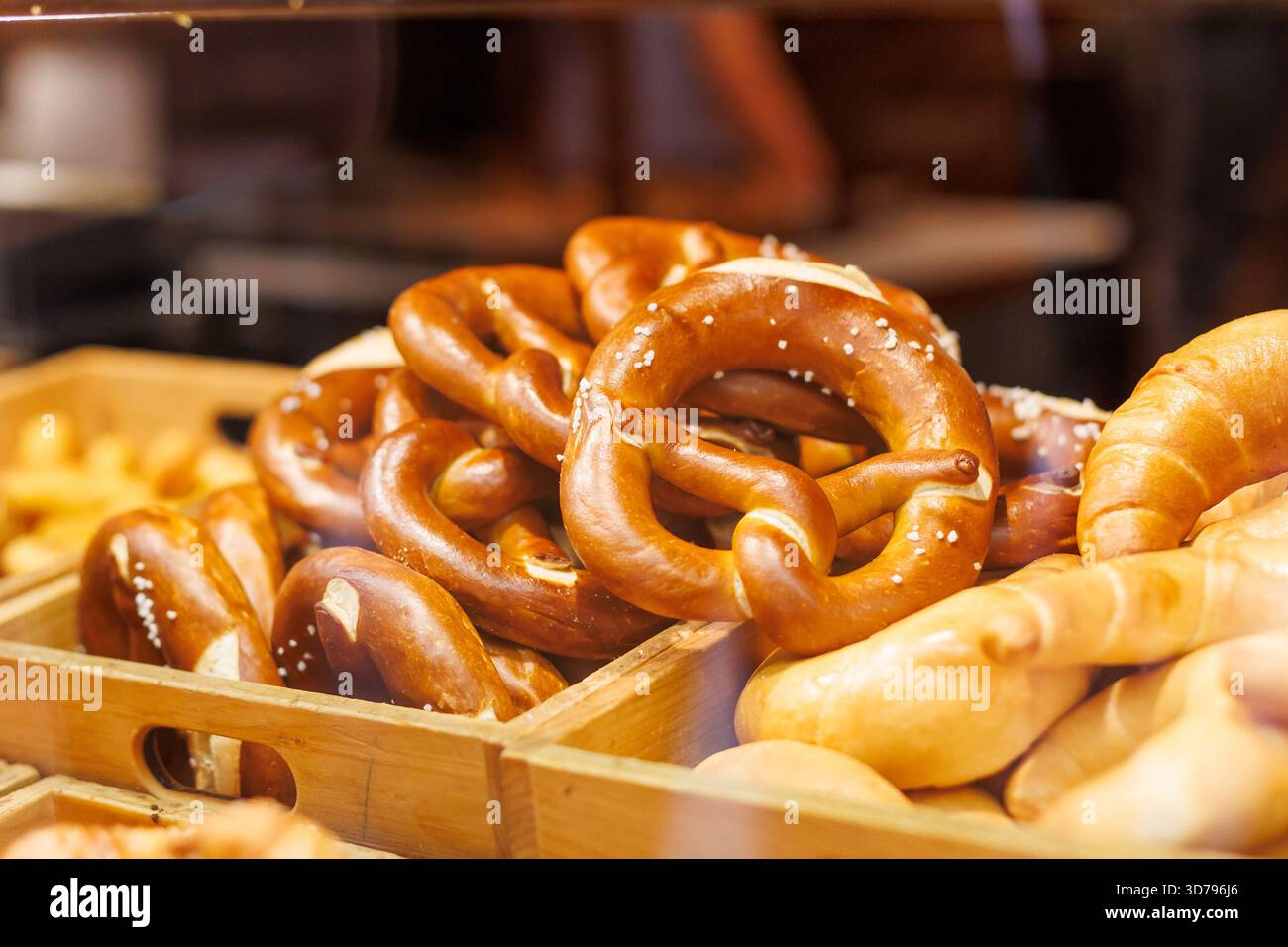 Pretzel appena sfornati esposti in una panetteria rustica con un'atmosfera calda Foto Stock