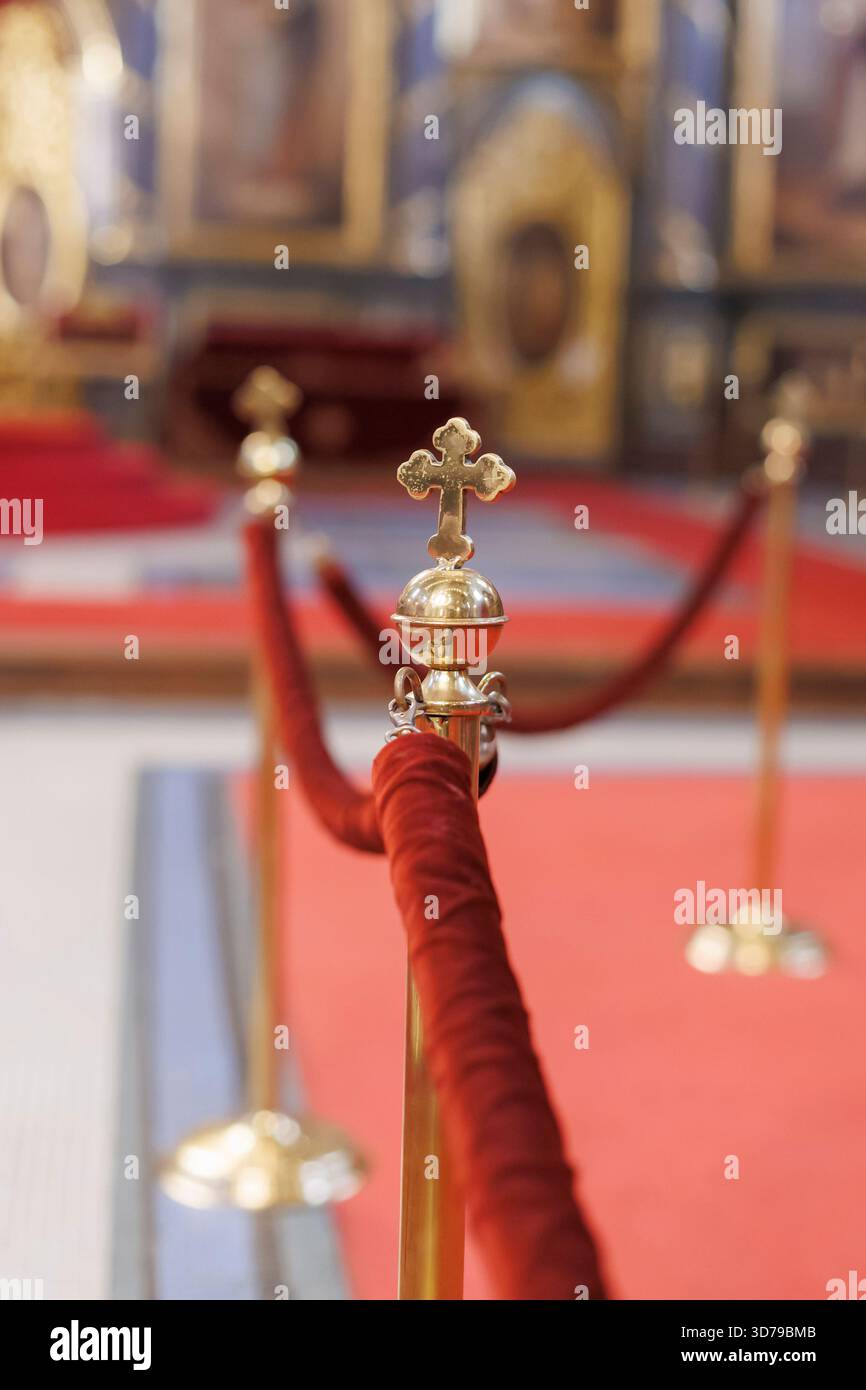 Elegante esposizione degli interni di una chiesa con ringhiere dorate e croce Foto Stock