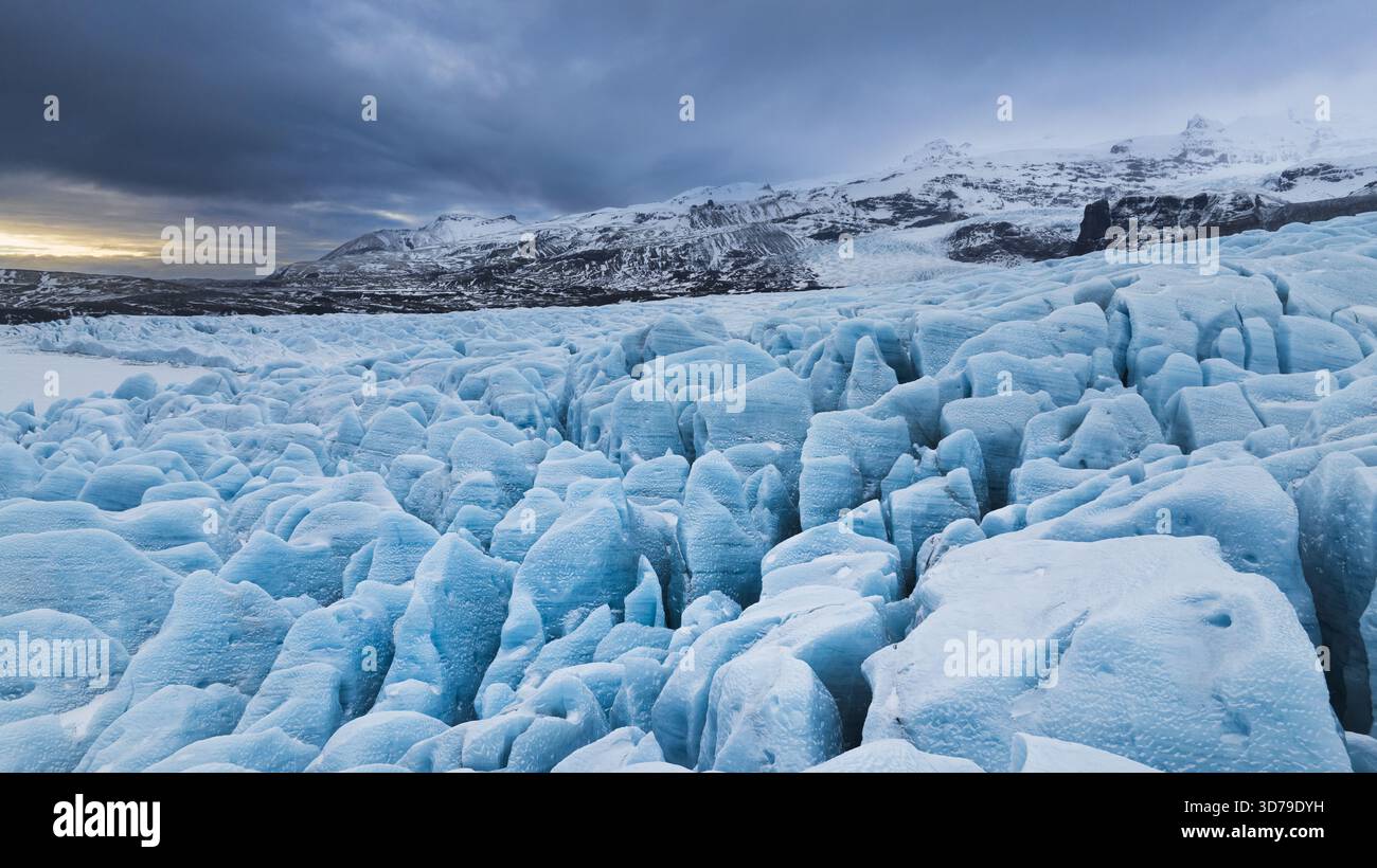Vista aerea delle formazioni di ghiaccio frastagliate incontra l'orizzonte sotto un cielo lunare vicino a Jokulsarlon, Sveitarfelagid Hornafjordur, Islanda. Foto Stock