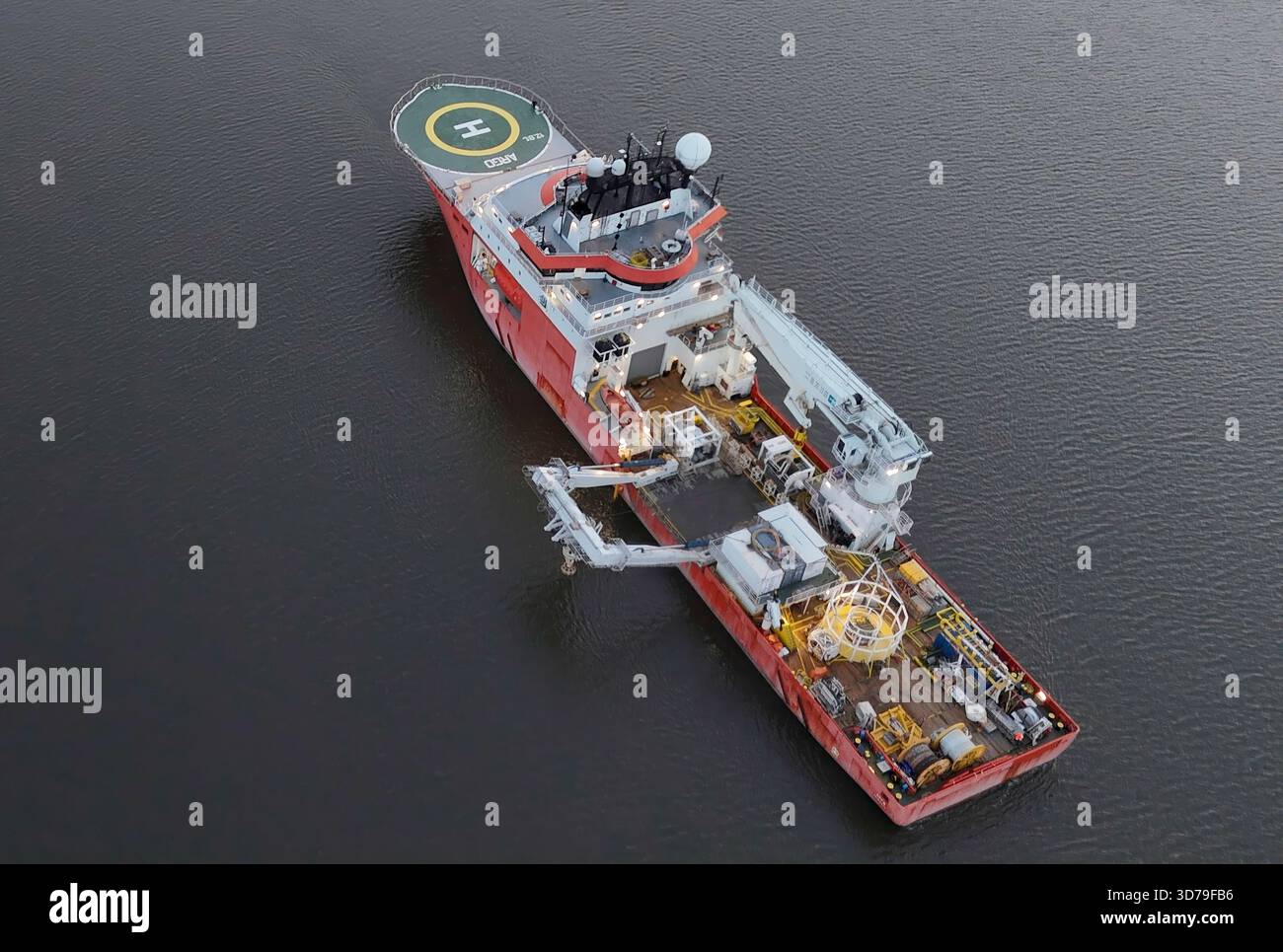 Vista aerea della vivace nave di servizio rossa e bianca che attraversa l'acqua scura, in contrasto con il cerchio duro dell'eliporto, Poughkeepsie, New Foto Stock