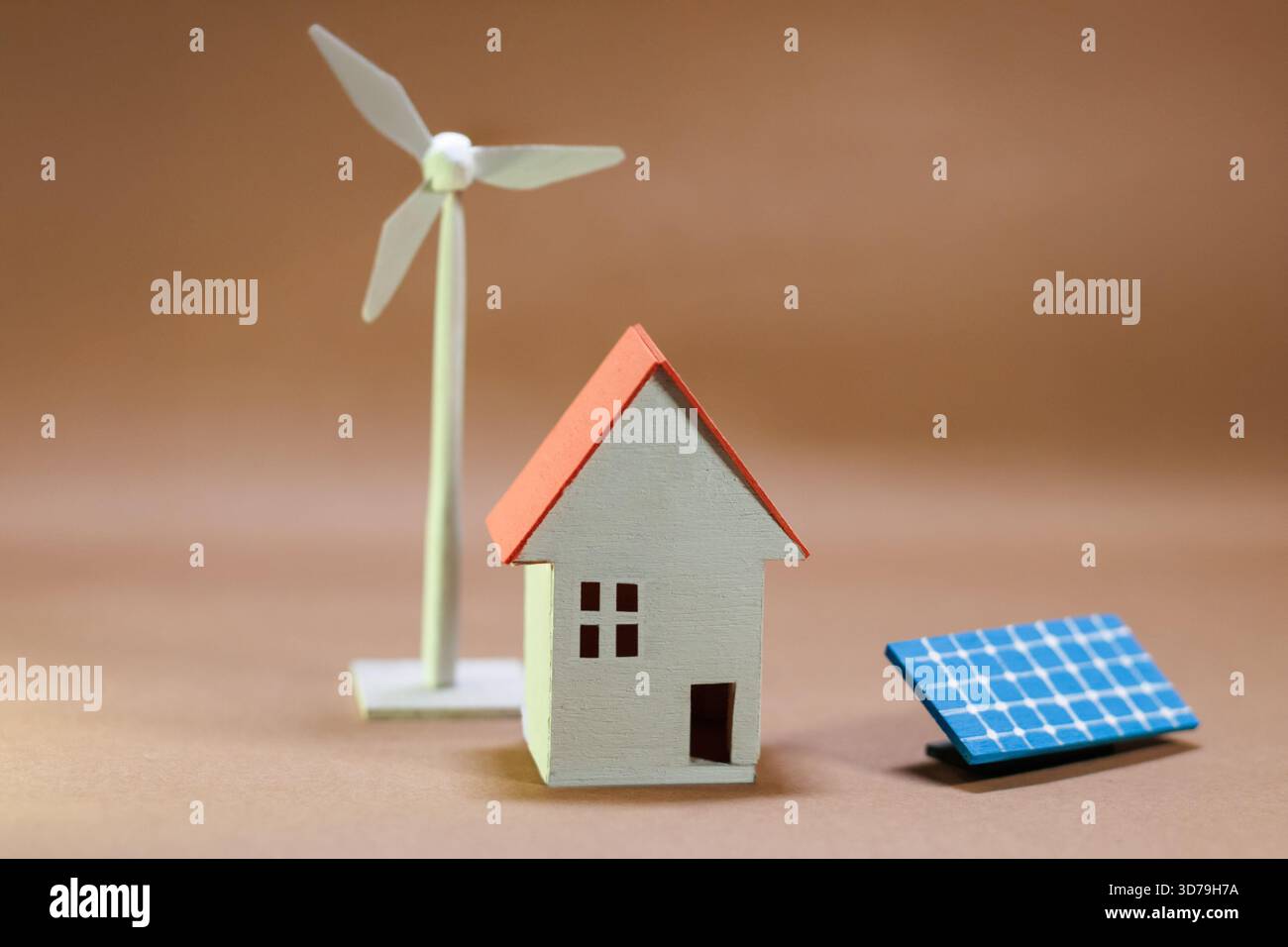 Modello che rappresenta l'energia rinnovabile con una casa, una turbina eolica e un pannello solare su sfondo neutro Foto Stock