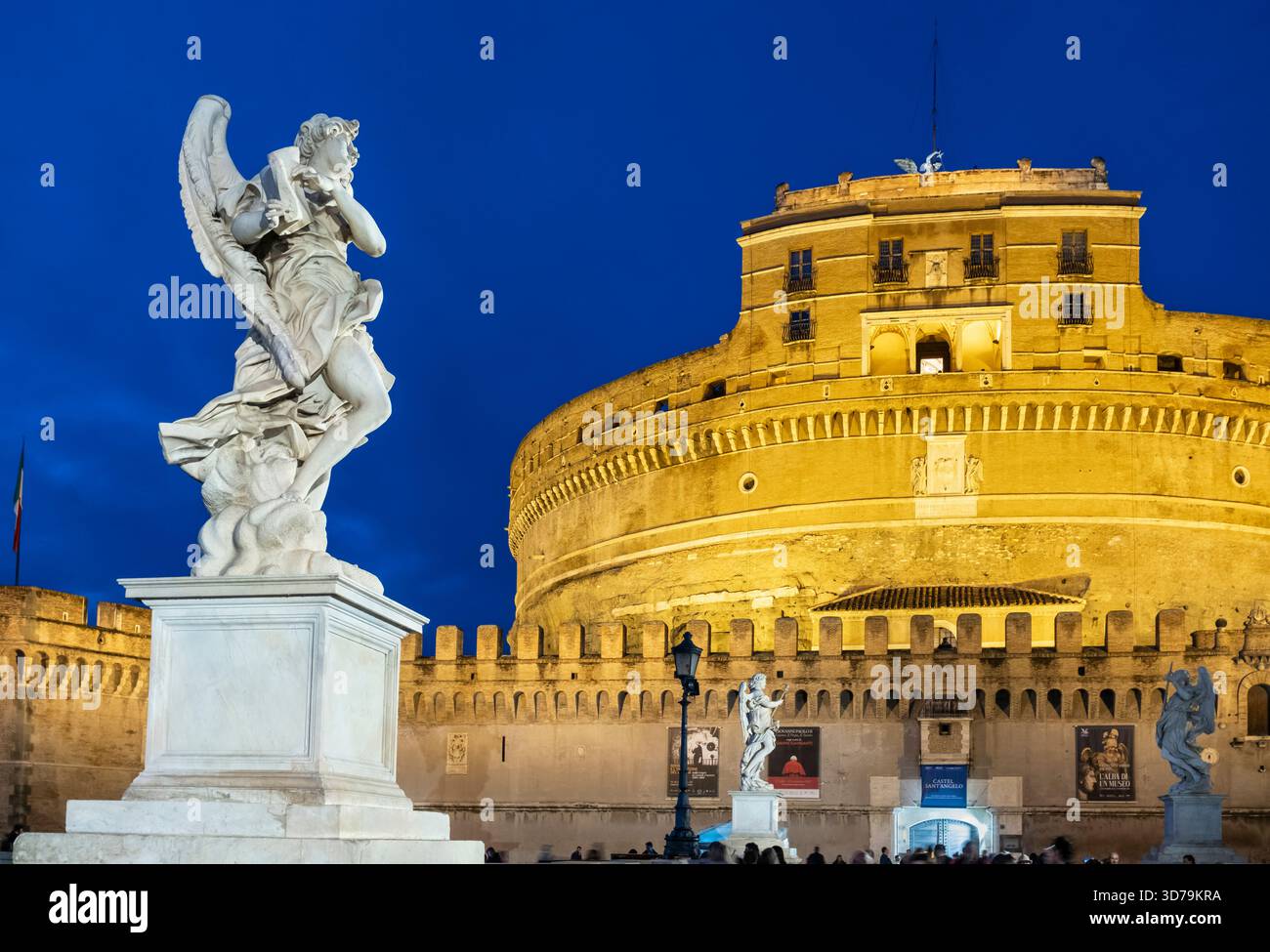Statue di angeli illuminate di notte sul Ponte Sant'Angelo, con sullo sfondo Castel Sant'Angelo. Roma, Italia. Foto Stock