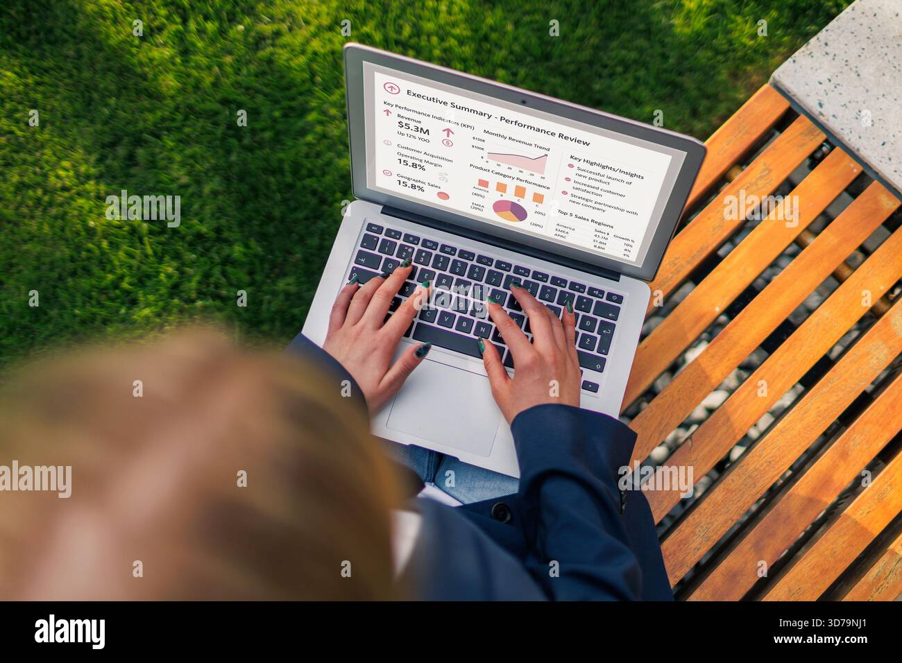 vista dall'alto di una giovane donna che lavora su un notebook in una panchina di un parco durante la revisione dei dati Foto Stock