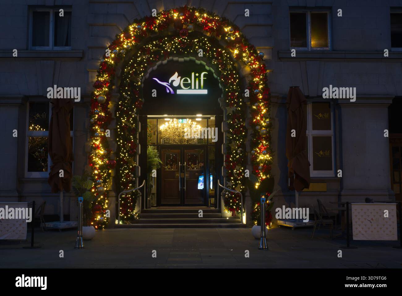 Ristorante Elif, Castle St, Liverpool. Ingresso dell'edificio incorniciato da un grande arco natalizio con luci calde e decorazioni festose. Foto Stock