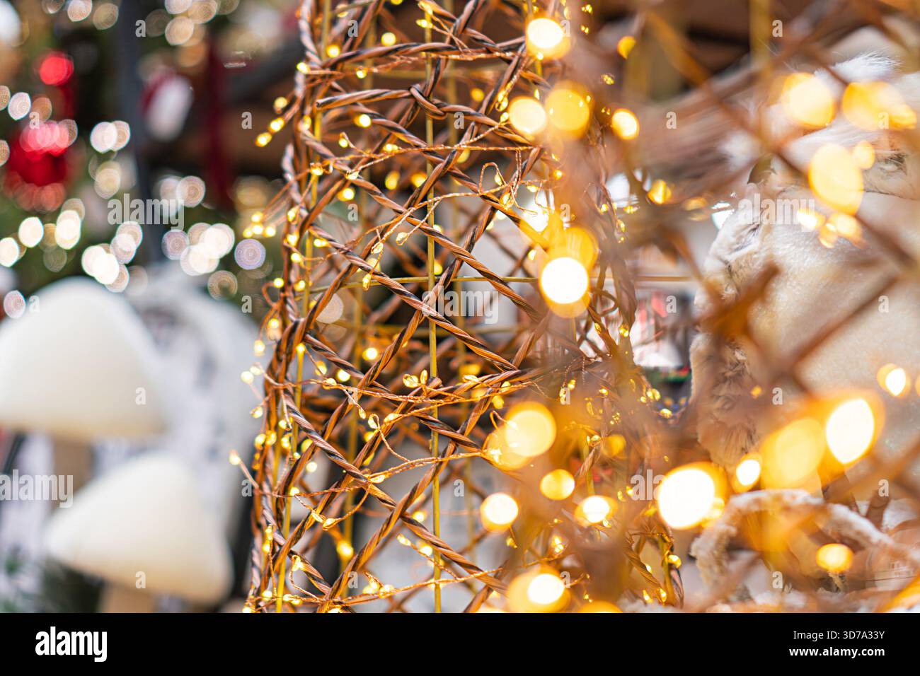 Scena natalizia con una struttura metallica illuminata, luci decorative, albero di Natale e decorazioni di Capodanno Foto Stock