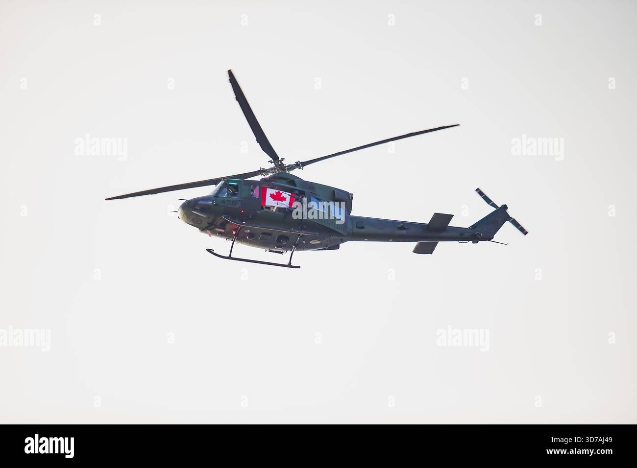 Velivolo aeronautico militare canadese che mostra fusoliera aerodinamica, slitte di atterraggio estese e lame rotanti mentre vola attraverso il cielo aperto e luminoso Foto Stock