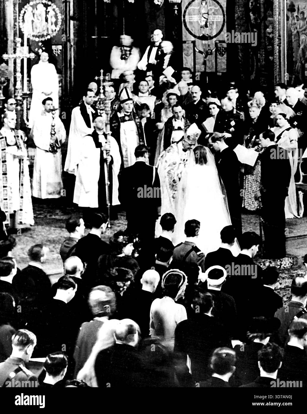 Royal Wedding: Bridegroom Places ring on Bride's finger – Westminster Abbey, 20 novembre mostrano lo sposo, il Duca di Edimburgo (centro destro), posizionando l'anello nuziale sul dito della sposa (principi Elisabetta), sulla sinistra della sposa c'è suo padre, Re Giorgio e sulla destra dello sposo il suo sposo il Marchese di Milford Haven, di fronte alla coppia nuziale c'è il Dr. Geoffrey Francis Fisher, arcivescovo di Canterbury, che ha solemnizzato il matrimonio. Di fronte alla prima fila di sedie (la coppia nuziale più vicina a destra) dal retro alla parte anteriore sono: La regina Maria; e il duca e la duchessa di Gloucester. In alto a sinistra di pi Foto Stock