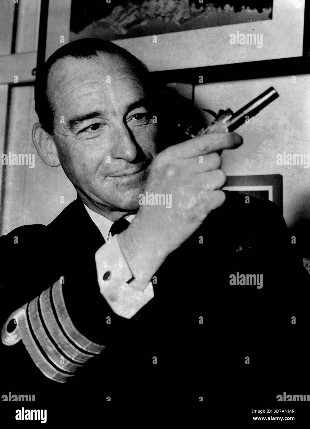 Capitano di Hmnzs Bellona.: Capitano G.V.M. Dolphin. RN -- C apt dell'Hmnzs Bellona, che è in una crociera di addestramento mondiale e ritorna visite ufficiali in India e Pakistan sulla strada per l'Inghilterra. Questo è Il revolver S un tempo appartenente al Bonny Prince Charles, al quale è stato chiesto di tornare dal nuovo Bonny Prince Charles da una famiglia di Auckland. 27 giugno 1952. (Foto di Gordon Herbert Short, G Coleman/Fairfax Media). Foto Stock
