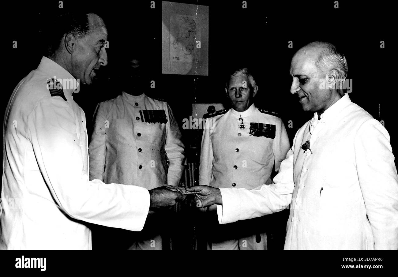Capitano, Dolphin che presenta il messaggio al primo Ministro. Sullo sfondo si possono vedere il vice ammiraglio C.T.M. Pizey, C-in-C, Indian Navy e il capitano G.S. Kapur, in (a sinistra).capitano G.V.M.Dolphin, capitano dell'incrociatore neozelandese "Bellona" ora in crociera di buona volontà verso l'India, ha fatto una visita ufficiale a Delhi il 4 agosto, per trasmettere al primo ministro dell'India il messaggio di saluto che gli è stato inviato dal primo ministro neozelandese. 4 agosto 1952. Foto Stock