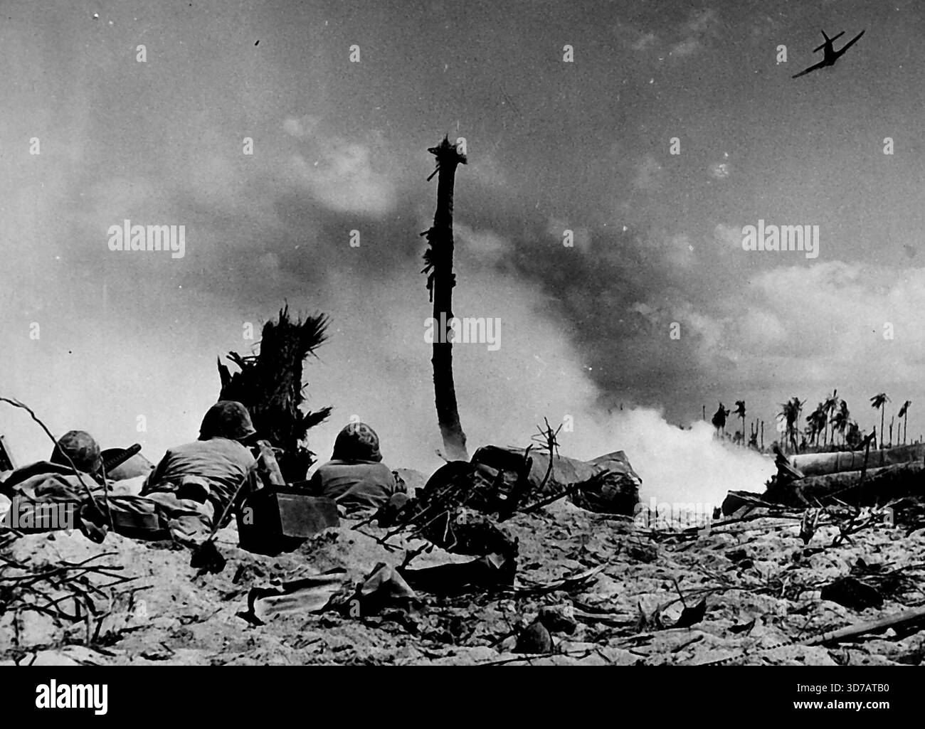 Abbattendo cecchini -- tre Marines strisciano verso un dugout Jap per eliminare cecchini durante la battaglia sull'atollo di Eniwetok nelle Marshalls, mentre un aereo americano si butta in testa. Questa foto è stata scattata da un cameraman della guardia costiera. 13 marzo 1944. (Foto di Officiall U.S. Coast Guard Photo). Foto Stock