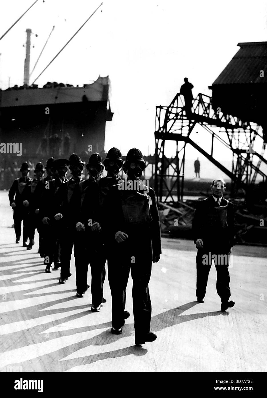 Formazione anti-gas per la politica di P.L.A. i membri della polizia di P.L.A. nelle maschere antigas durante l'istruzione anti-gas di questa mattina.i membri della polizia delle autorità del porto di Londra non sono sotto addestramento anti-gas da parte di istruttori del dipartimento di precauzioni antiaerea dell'ufficio di casa, al Royal Albert Dock. 23 febbraio 1938. (Foto di Keystone). Foto Stock