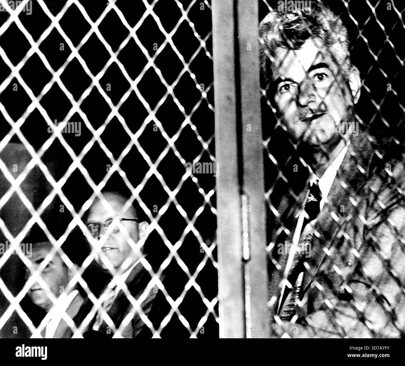 La tenda d'acciaio cade sui leader rossi -- Eugene Dennis (a destra), Segretario generale del Partito Comunista in America, e tre dei migliori rossi degli Stati Uniti siedono dietro la porta d'acciaio nel furgone della prigione mentre lasciano il tribunale federale qui oggi per la Casa Federale di detenzione. Condannati nel 1949 con l'accusa di aver sostenuto il rovesciamento violento del governo degli Stati Uniti, gli fu ordinato di iniziare subito le sentenze. Da sinistra a destra ci sono John Gates, John Williamson, Benjamin Davis Jr., parzialmente oscurato dalla porta, e Dennis. 2 luglio 1951. (Foto di AP Wirephoto). Foto Stock