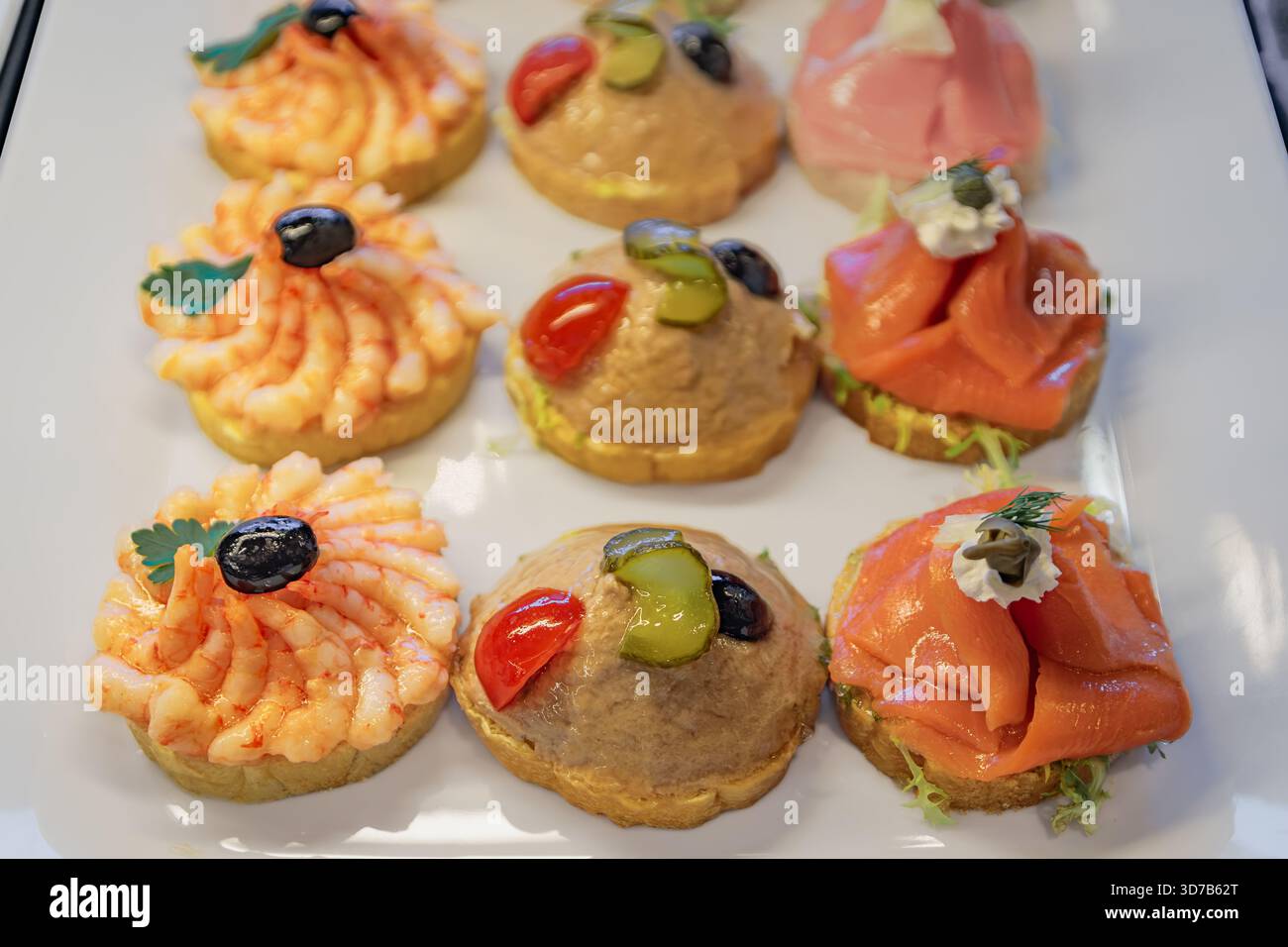 Panini a vista Belegte Brotli con gamberetti, insalata di tonno e salmone affumicato su un piatto bianco da portata in vendita in una panetteria di Zurigo, Svizzera Foto Stock