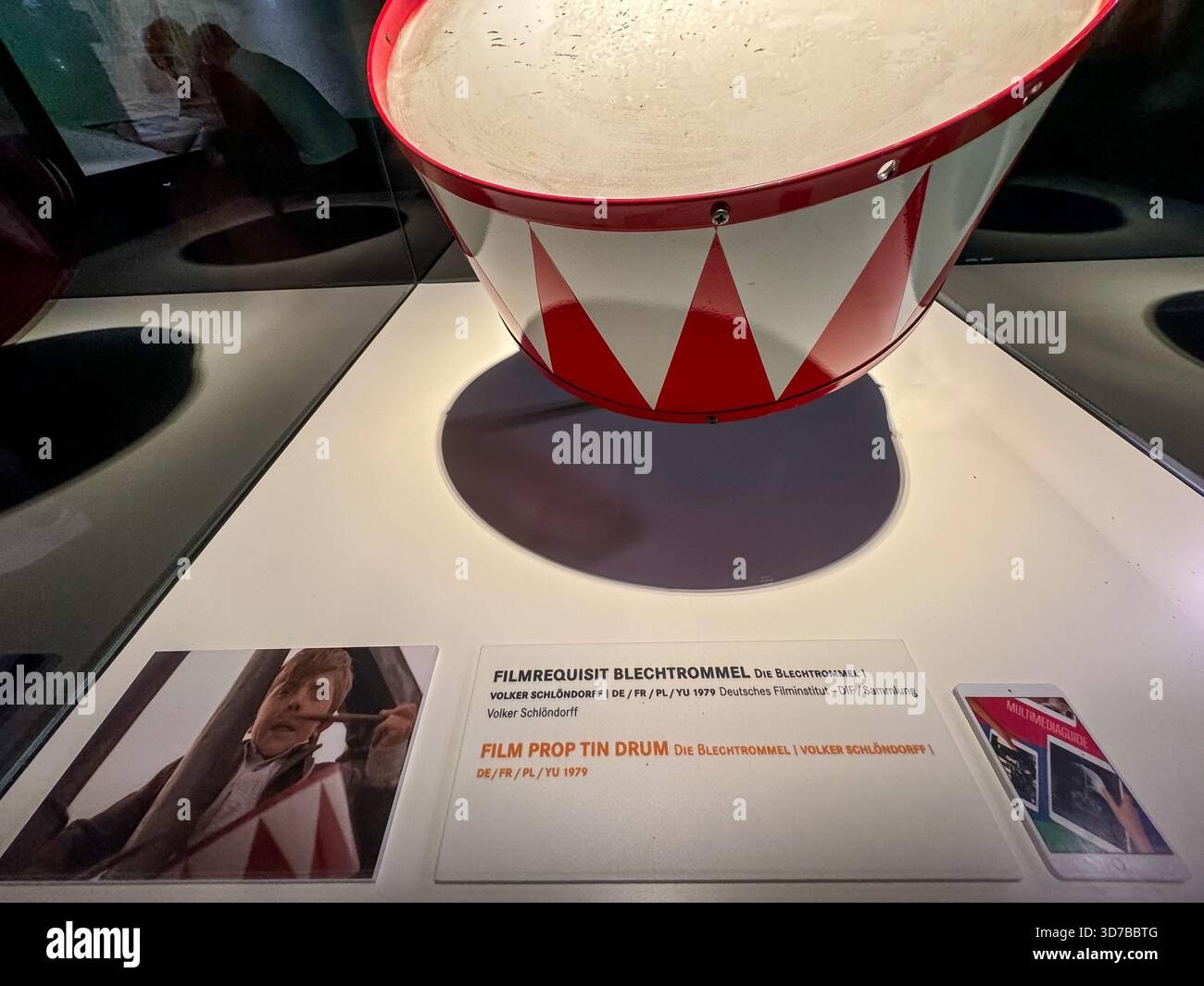Tamburo di supporto utilizzato nel tamburo di latta esposto con testo descrittivo all'interno della mostra del museo del cinema tedesco sulla storia del cinema. Foto Stock