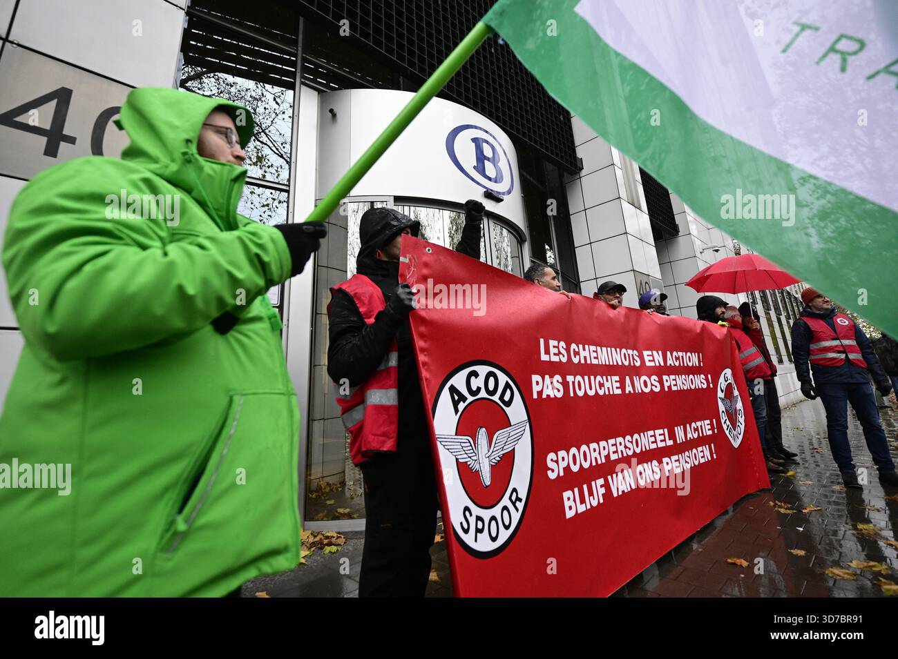 Lavoratori con bandiere e striscioni di ACV - CSC union transcom e CGSP - ACOD nella foto di una marcia simbolica dei sindacati ferroviari verso la sede delle compagnie ferroviarie, il primo giorno di uno sciopero nazionale di 72 ore indetto dai sindacati del trasporto pubblico ferroviario, a Bruxelles, lunedì 24 novembre 2025. Mantenere l'indice, rafforzare la sicurezza sociale e garantire un'equa partecipazione ai contributi previdenziali sono tutte esigenze volte a combattere la divisione sociale e a promuovere una maggiore giustizia sociale. Domani altri servizi pubblici si uniranno al movimento e mercoledì arriverà tutto il settore Foto Stock
