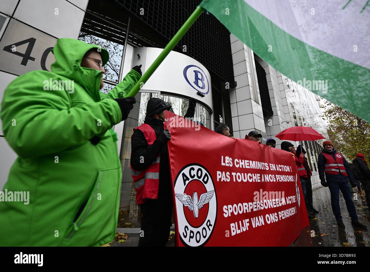 Lavoratori con bandiere e striscioni di ACV - CSC union transcom e CGSP - ACOD raffigurato davanti alla SNCB - uffici NMVB in una marcia simbolica dei sindacati ferroviari verso la sede delle compagnie ferroviarie, il primo giorno di uno sciopero nazionale di 72 ore indetto dai sindacati del trasporto pubblico ferroviario, a Bruxelles, lunedì 24 novembre 2025. Mantenere l'indice, rafforzare la sicurezza sociale e garantire un'equa partecipazione ai contributi previdenziali sono tutte esigenze volte a combattere la divisione sociale e a promuovere una maggiore giustizia sociale. Domani altri servizi pubblici si uniranno al movimento e o Foto Stock