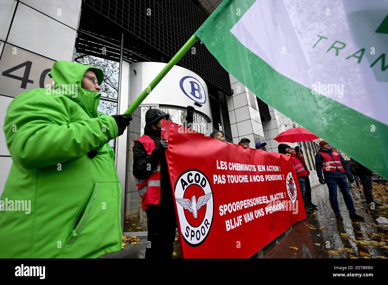 Lavoratori con bandiere e striscioni di ACV - CSC union transcom e CGSP Cheminots - ACOD Spoor nella foto di una marcia simbolica dei sindacati ferroviari verso la sede delle compagnie ferroviarie, il primo giorno di uno sciopero nazionale di 72 ore indetto dai sindacati del trasporto pubblico ferroviario, a Bruxelles, lunedì 24 novembre 2025. Mantenere l'indice, rafforzare la sicurezza sociale e garantire un'equa partecipazione ai contributi previdenziali sono tutte esigenze volte a combattere la divisione sociale e a promuovere una maggiore giustizia sociale. Domani altri servizi pubblici si uniranno al movimento e mercoledì tutti Foto Stock