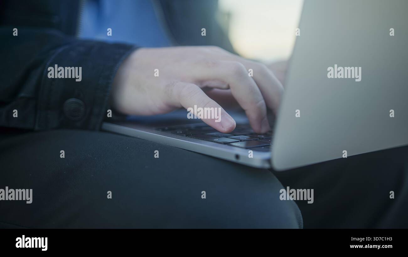 Primo piano della digitazione manuale sulla tastiera di un notebook Foto Stock