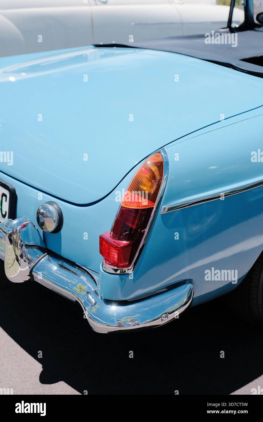 Vista ravvicinata della sezione posteriore di un'auto vintage azzurra, con paraurti cromato, classico fanalino di coda, linee della carrozzeria morbide e stile retrò. Foto Stock