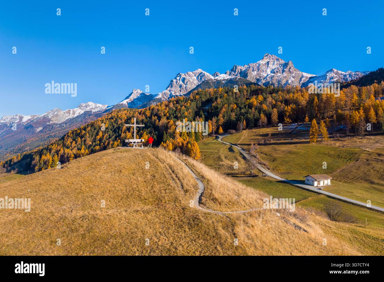 Vista aerea di una persona che ammira le montagne che circondano Tarasp in autunno. Bassa Engadina, Cantone dei Grigioni, Svizzera, Europa. Foto Stock