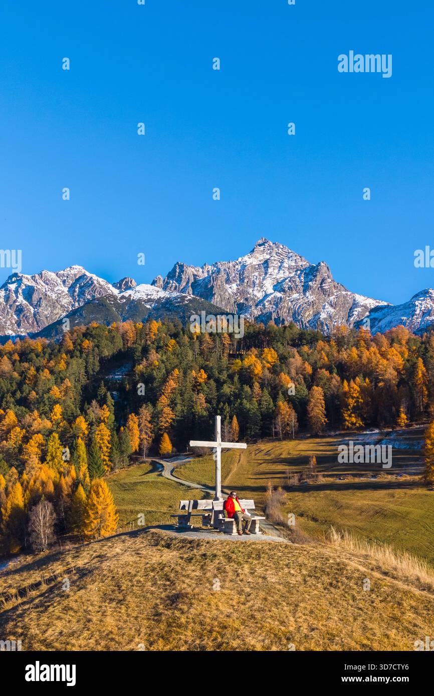Vista aerea di una persona che ammira le montagne che circondano Tarasp in autunno. Bassa Engadina, Cantone dei Grigioni, Svizzera, Europa. Foto Stock