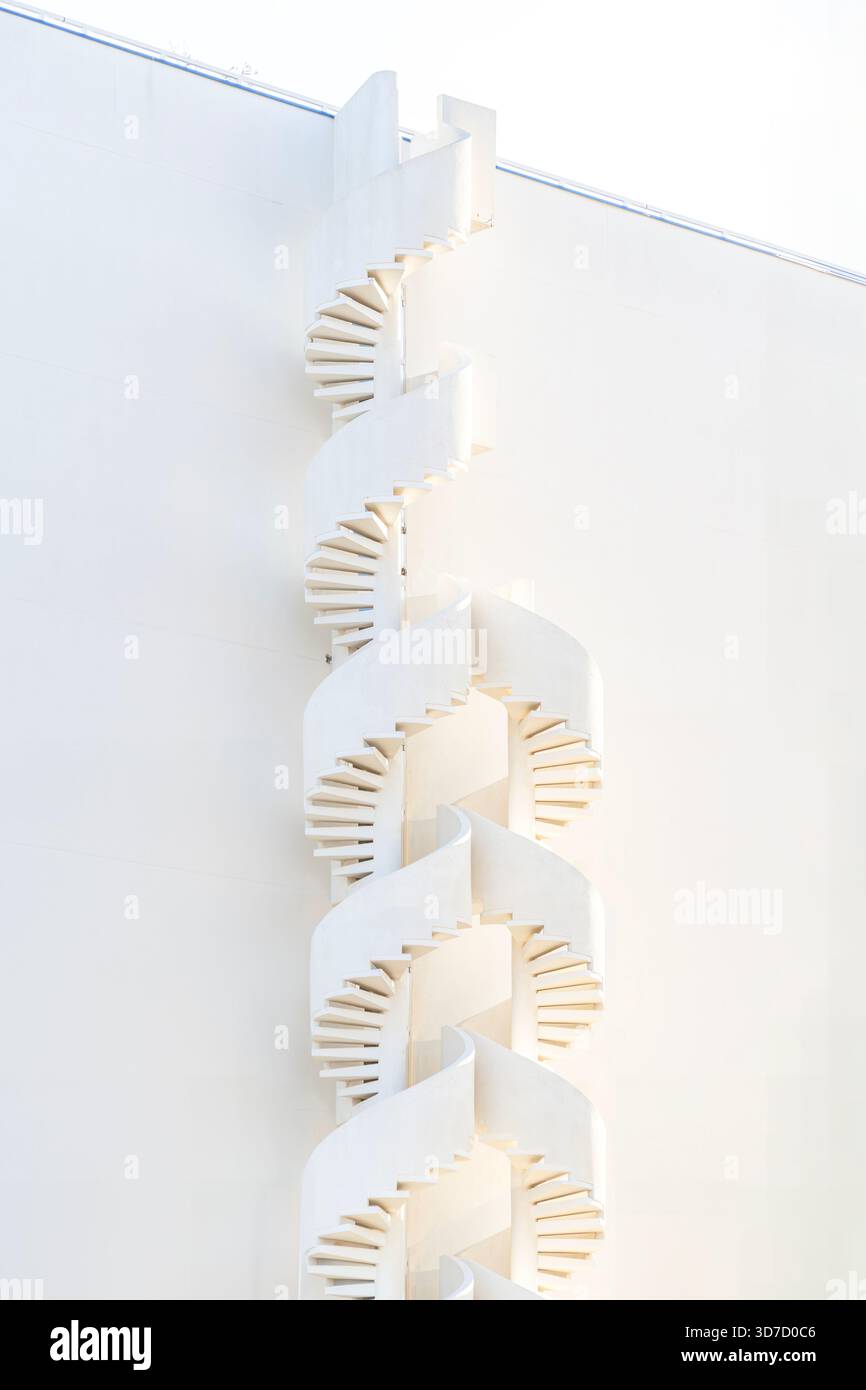 Dettagli architettonici minimalisti e astratti di una scala a spirale continua su una parete bianca, creando un design pulito e moderno Foto Stock