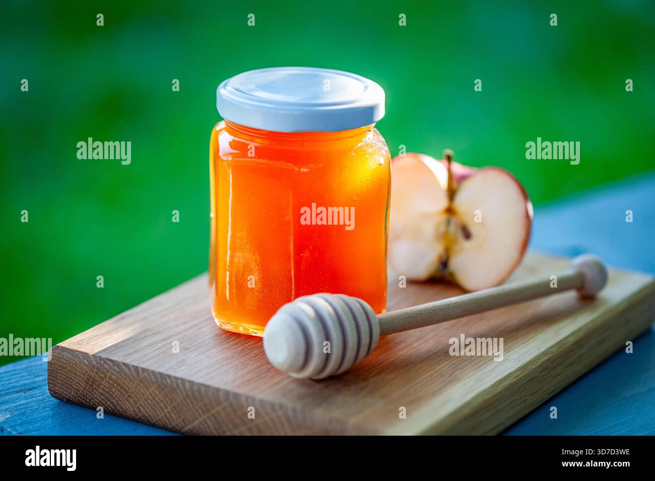 Marmellata di mele fatta in casa in barattolo con mela fresca e cucchiaia di legno sul tagliere. Spalmazione di frutta naturale. Foto Stock