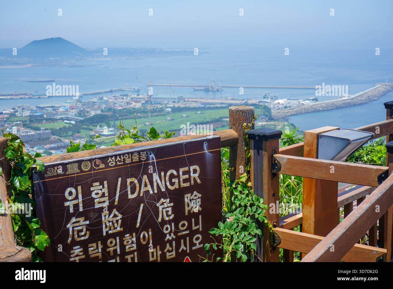 Cartello di pericolo sulla cima del vulcano Seongsan Ilchulbong, chiamato anche Sunrise Peak, con città e spiaggia sotto Seogwipo, isola di Jeju, Corea del Sud Foto Stock