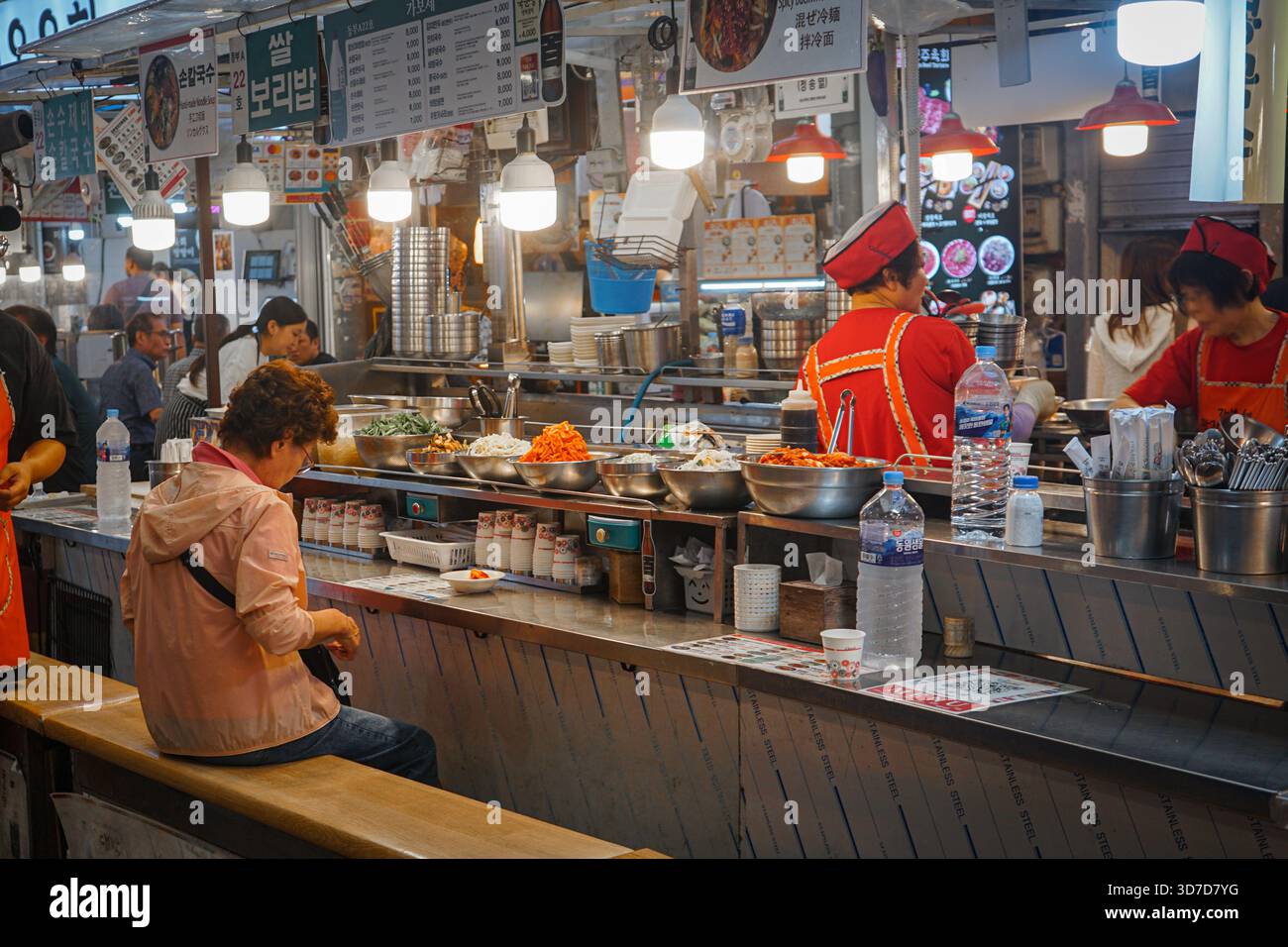 Il Lone Diner mangia un pasto in un chiosco di cibo nell'affollato mercato di Gwangjang a Seoul, Corea del Sud Foto Stock