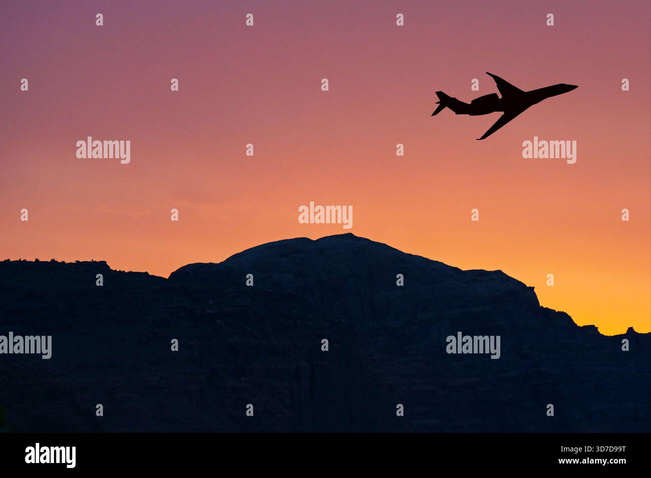 Jet privato executive che decolla su una montagna con un cielo colorato al tramonto Foto Stock