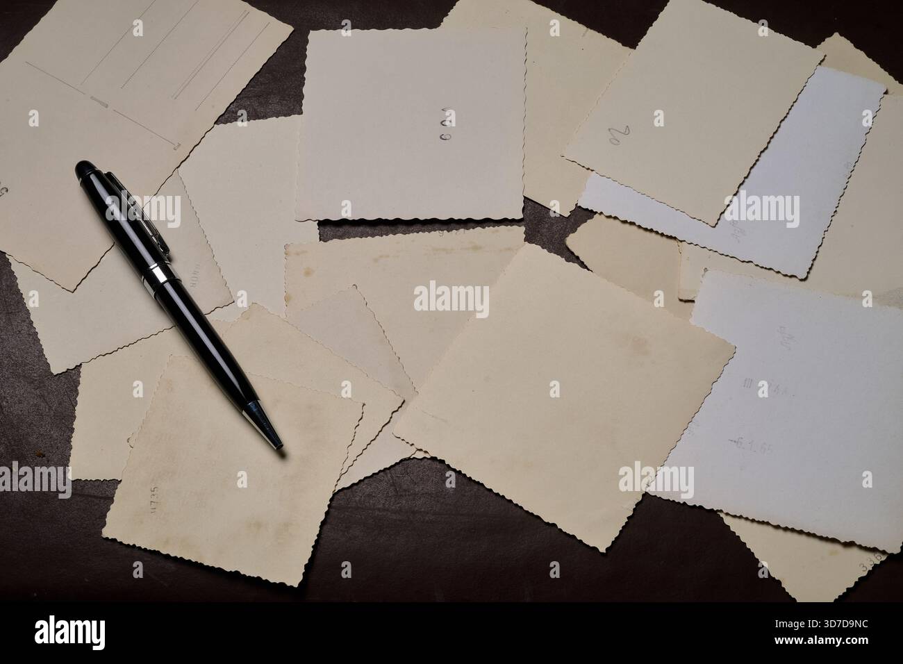 Il retro di alcune vecchie foto e di una penna Foto Stock