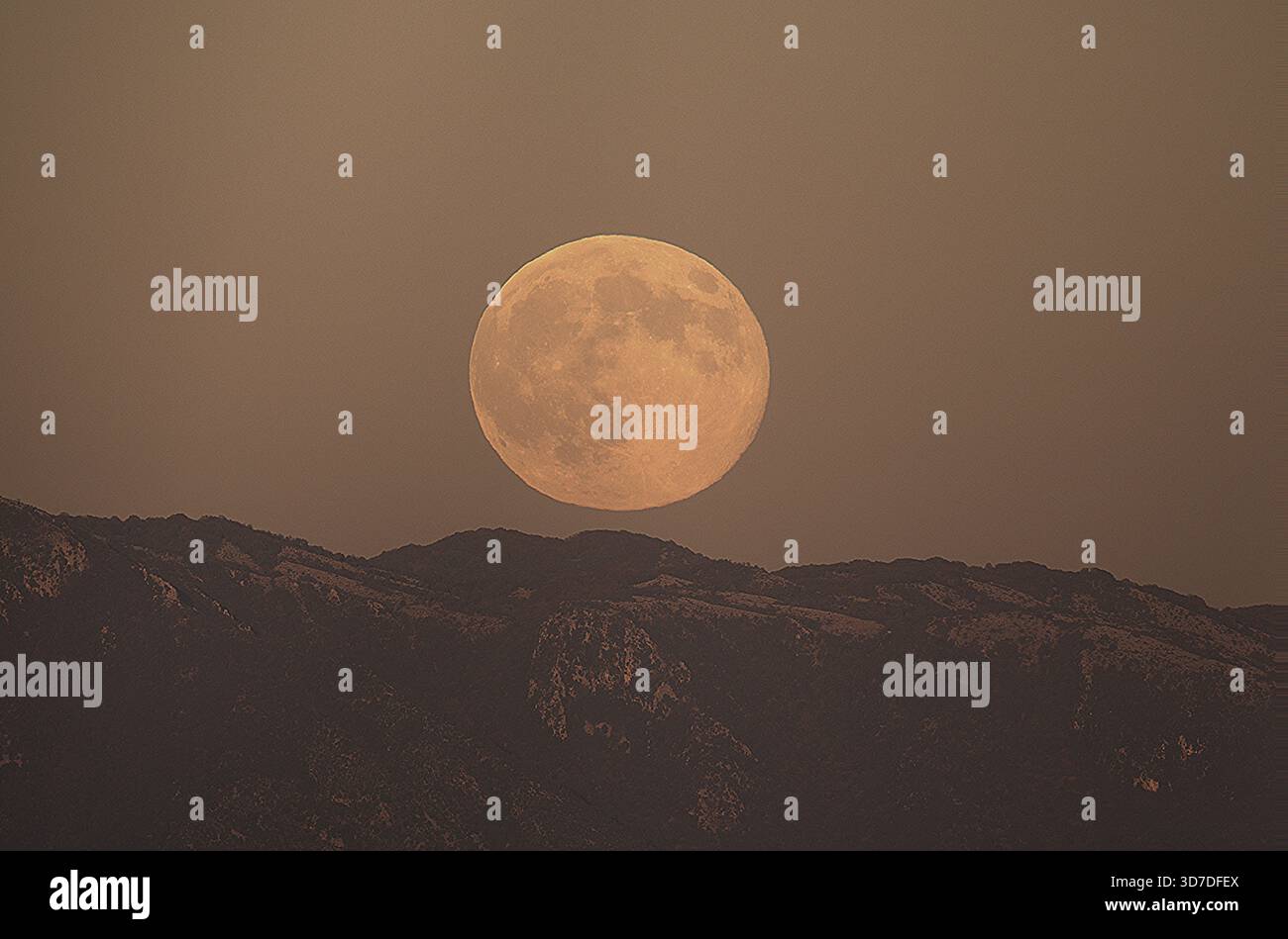 Luna piena che si innalza sopra il paesaggio delle montagne con vista panoramica del cielo notturno Foto Stock