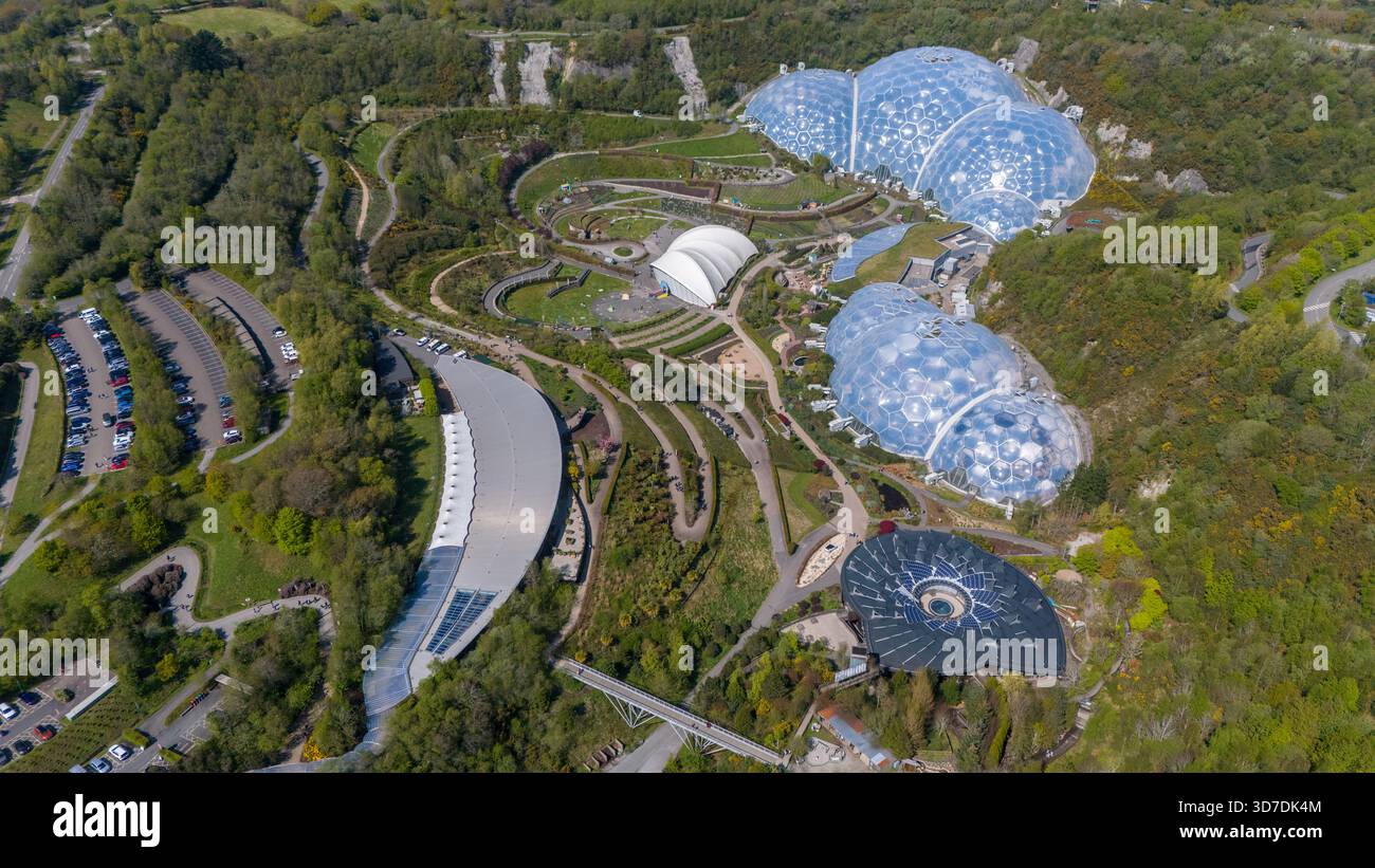 Vista aerea degli iconici biomi dell'Eden Project, annidato in mezzo a una lussureggiante vegetazione, con la sua architettura futuristica in contrasto con la natura Foto Stock