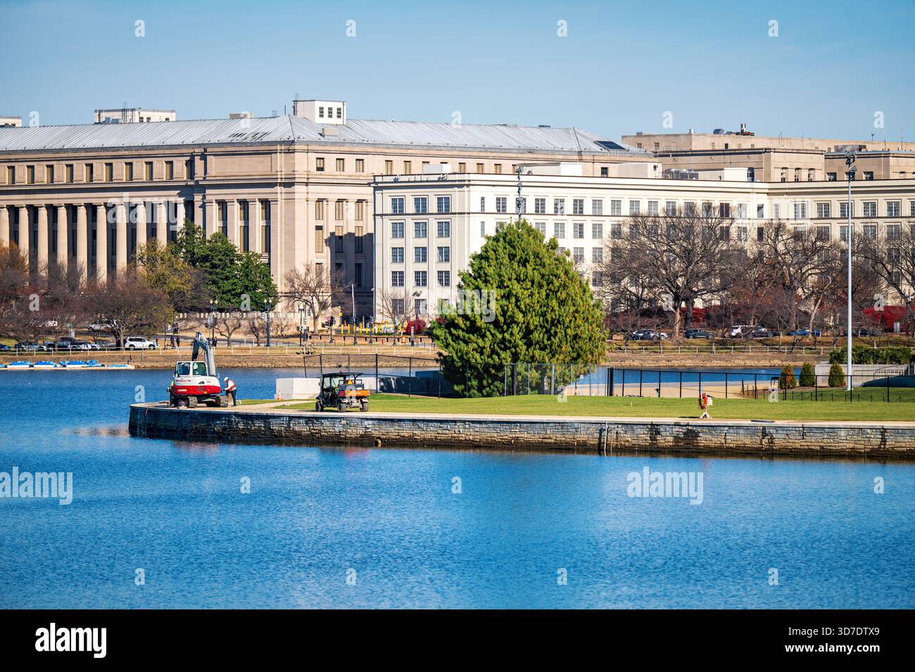 WASHINGTON DC - il progetto Tidal Basin Seawall Construction Project è in corso nell'angolo meridionale del bacino Tidal il 24 novembre 2025, con un escavatore visibile sulla diga appena rinforzata. Questo progetto di infrastrutture critiche mira ad affrontare il cedimento e l'innalzamento del livello del mare che incidono sull'iconico punto di riferimento di Washington DC. Il punto di vista è dall'Inlet Bridge verso il Jefferson Memorial, con il Bureau of Engraving and Printing e il U.S. Holocaust Memorial Museum visibili sullo sfondo. Il bacino delle maree è un bacino artificiale che fa parte del National Mall, circondato da Foto Stock