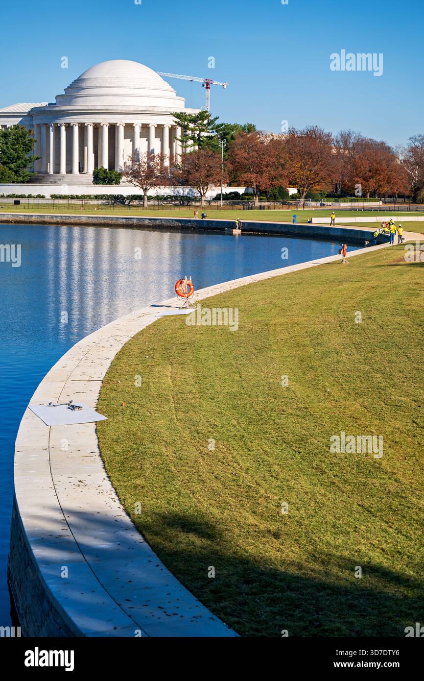 WASHINGTON DC - il Tidal Basin Seawall Construction Project è in corso nell'angolo meridionale del Tidal Basin, visto da Inlet Bridge verso il Jefferson Memorial il 24 novembre 2025. I lavoratori sono impegnati nel miglioramento delle infrastrutture lungo la diga e nell'acqua. Questo ampio progetto affronta il deterioramento delle banchine e le inondazioni croniche, vitali per proteggere i monumenti iconici. Il Thomas Jefferson Memorial, un monumento neoclassico, è una caratteristica importante sullo sfondo. Dietro il monumento è visibile anche una grande gru da cantiere, che indica i lavori correlati. Il progetto invo Foto Stock