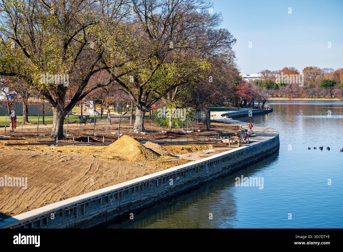 WASHINGTON DC - il Tidal Basin Seawall Construction Project è in corso nell'angolo meridionale del bacino Tidal, visto il 24 novembre 2025. Questo vasto progetto del National Park Service mira a riparare e sollevare i fondali marini per combattere il cedimento e le inondazioni delle maree, proteggendo monumenti iconici e ciliegi. La prospettiva è dall'Inlet Bridge, guardando verso il Franklin Delano Roosevelt Memorial e Martin Luther King Jr. Memorial. Nuove sezioni di pietra della diga sono visibili lungo il bordo dell'acqua, con la terra preparata dietro di loro. Foto Stock