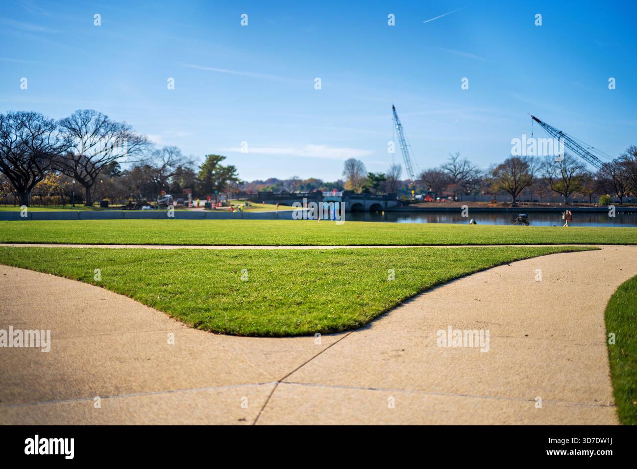 WASHINGTON DC - il Tidal Basin Seawall Construction Project è in corso nell'angolo meridionale del bacino Tidal il 24 novembre 2025. Questa vista si affaccia a ovest da vicino al Jefferson Memorial verso l'Inlet Bridge. Il progetto mira a riparare e sollevare i fondali marini, affrontando il cedimento e le inondazioni ricorrenti. Gru e attrezzature sono visibili sull'acqua, a indicare il lavoro in corso. Il bacino delle maree, un bacino artificiale artificiale e parte fondamentale del National Mall, è famoso per i suoi alberi di ciliegio in fiore. Foto Stock