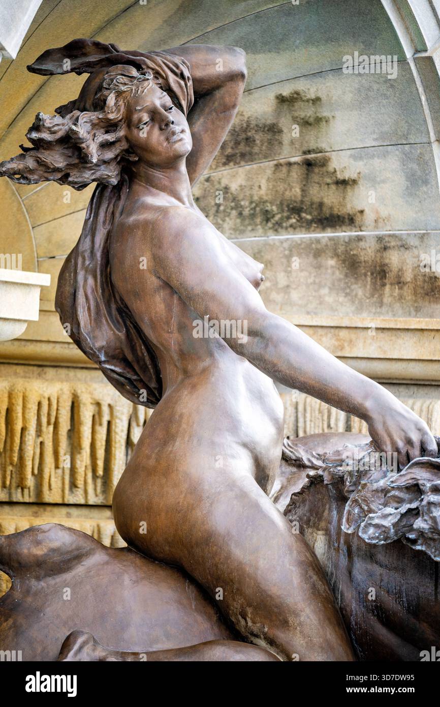 WASHINGTON DC — Una scultura di bronzo di naiad fa parte della Court of Nettune Fountain presso la Library of Congress Thomas Jefferson Building. Progettata da Roland Hinton Perry e completata il 23 febbraio 1898, questa fontana semicircolare in bronzo e granito larga 50 piedi (15 metri) è un risultato determinante della scultura Beaux-Arts americana. Ispirato alla Fontana di Trevi di Roma, presenta figure mitologiche in scala eroica, tra cui due naiadi di 3 metri che cavalcano ippocampi, fuse dalla Henry-Bonnard Bronze Company. Proclamata la fontana più ornata degli Stati Uniti al completamento, rappresenta l'apice Foto Stock
