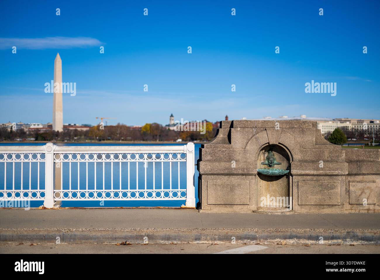WASHINGTON DC - due fontane di pietra, con facce simili a pesci, adornano le alcove sull'Inlet Bridge presso il bacino delle maree, con il Monumento a Washington visibile oltre. Create dallo scultore greco Constantine Seferlis intorno al 1987, queste caratteristiche acquatiche uniche rendono omaggio a Manus “Jack” Fish, ex direttore regionale del National Park Service. Fish ha supervisionato grandi progetti come Constitution Gardens e il Vietnam Veterans Memorial. Le sculture fondono giocosamente le caratteristiche di Fish con un corpo simile a un pesce, facendo riferimento al suo nome e alla sua eredità. Sostituirono le fontane originali in bronzo precedentemente nelle alcove. Foto Stock