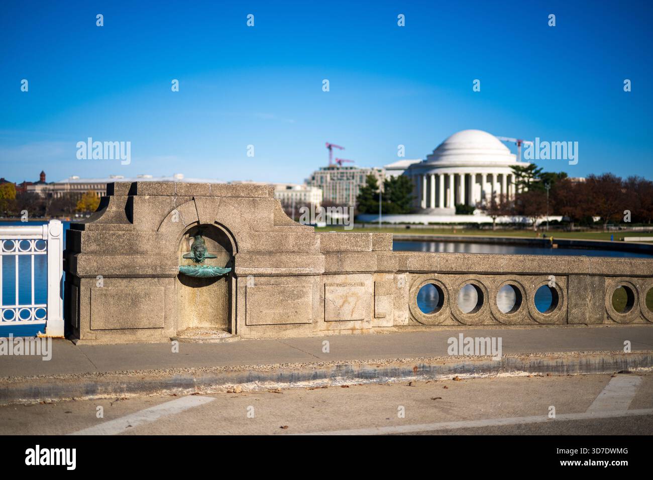 WASHINGTON DC - la scultura della Manus Jack Fish Fountain si trova sull'Inlet Bridge presso il bacino delle maree. Questa scultura in bronzo, creata da Constantine Seferlis nel 1987, rende omaggio a Manus 'Jack' Fish. Fish è stato un ex direttore regionale del National Park Service per la National Capital Region. Ha supervisionato importanti progetti di Washington DC, tra cui Constitution Gardens e Vietnam Veterans Memorial. I volti stravaganti fondono le caratteristiche di Fish con un corpo simile a un pesce, un giocoso richiamo al suo nome e alla sua eredità. Foto Stock