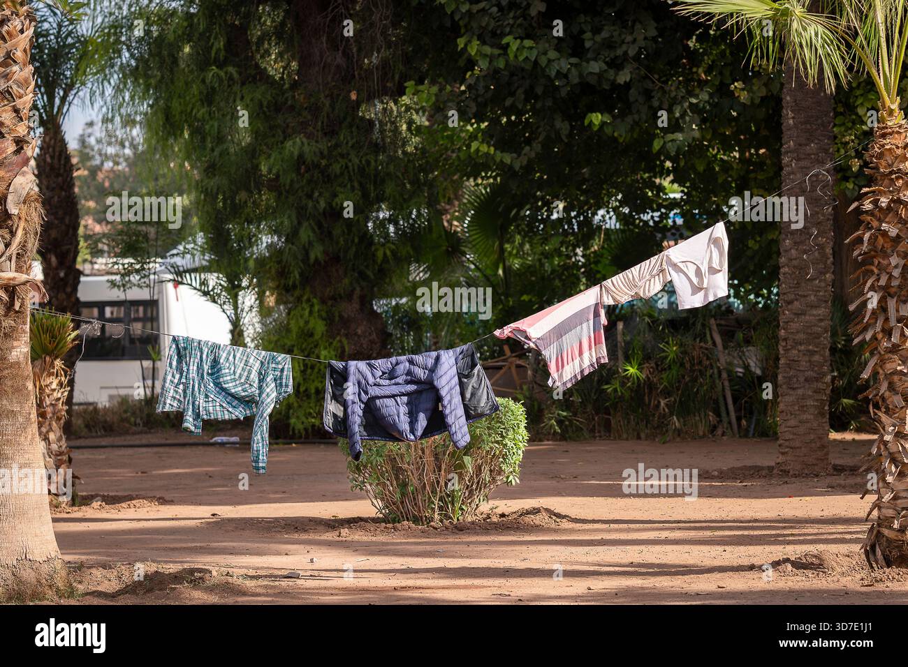 La lavanderia si asciuga in fila in un parco cittadino, Marrakech. Vestiti appesi su una linea di lavaggio in uno spazio verde cittadino per asciugare. Foto Stock
