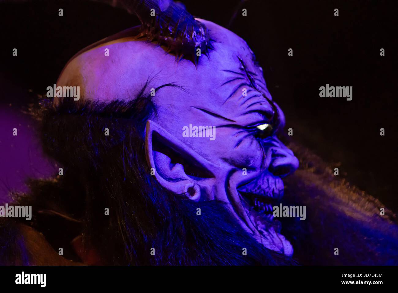 Un krampus cornuto partecipa a una sfilata di strada festosa in stile tradizionale Foto Stock