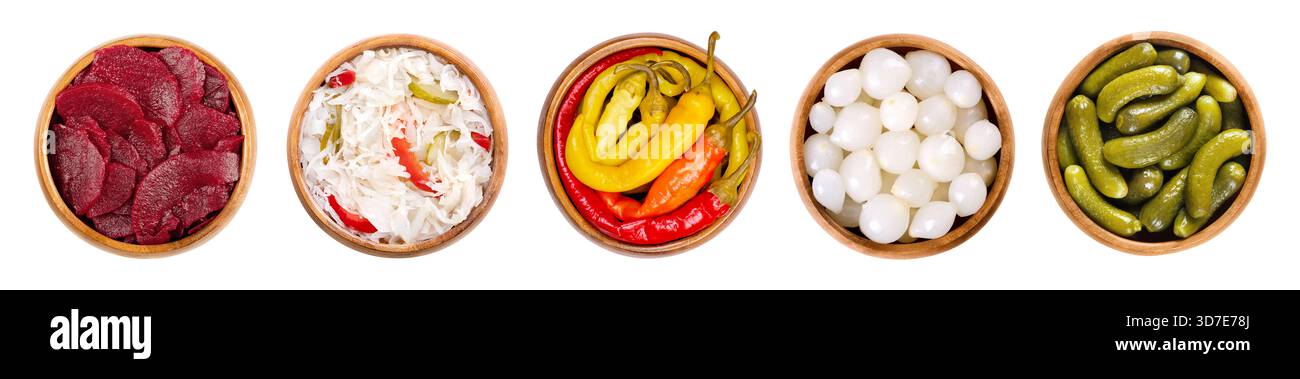 Verdure sottaceto in ciotole di legno. Fette di barbabietola da sinistra a destra, puszta coleslaw, peperoni, cipolle perlate e cetriolini croccanti. Foto Stock