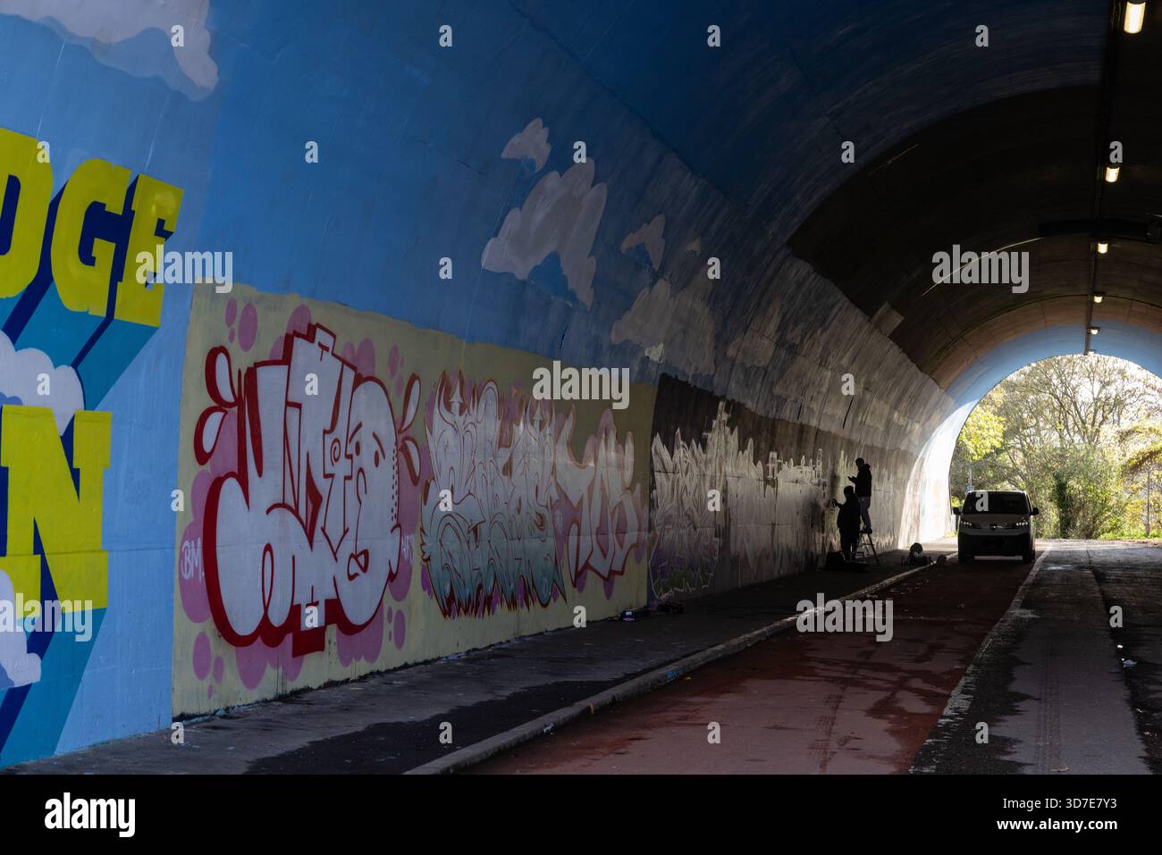 Artisti di graffiti che lavorano in un tunnel, Chepstow, Monmouthshire, Galles, Regno Unito Foto Stock