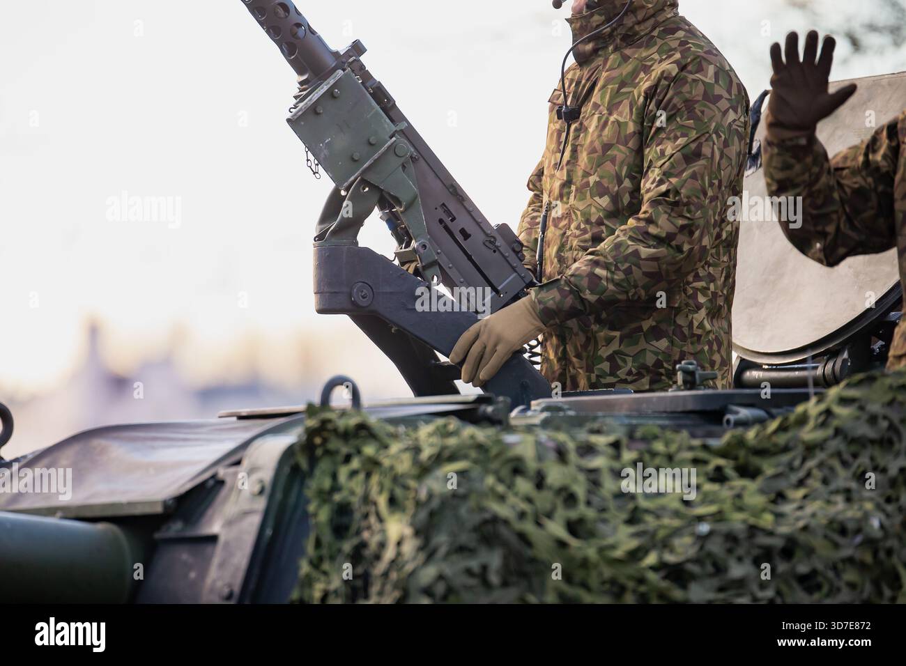 Membro dell'equipaggio della piattaforma corazzata NATO che opera sul sistema d'arma pesante montato esternamente durante la mostra delle forze di terra alleate mettendo in evidenza il combattimento Foto Stock