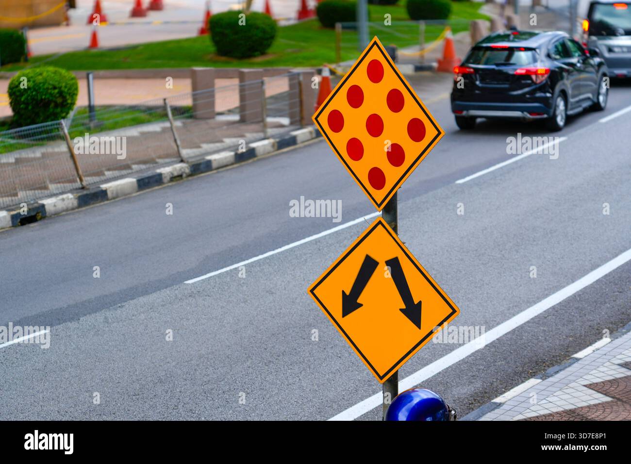 Freccia e puntini rossi su sfondo giallo sulla strada della città. Foto Stock