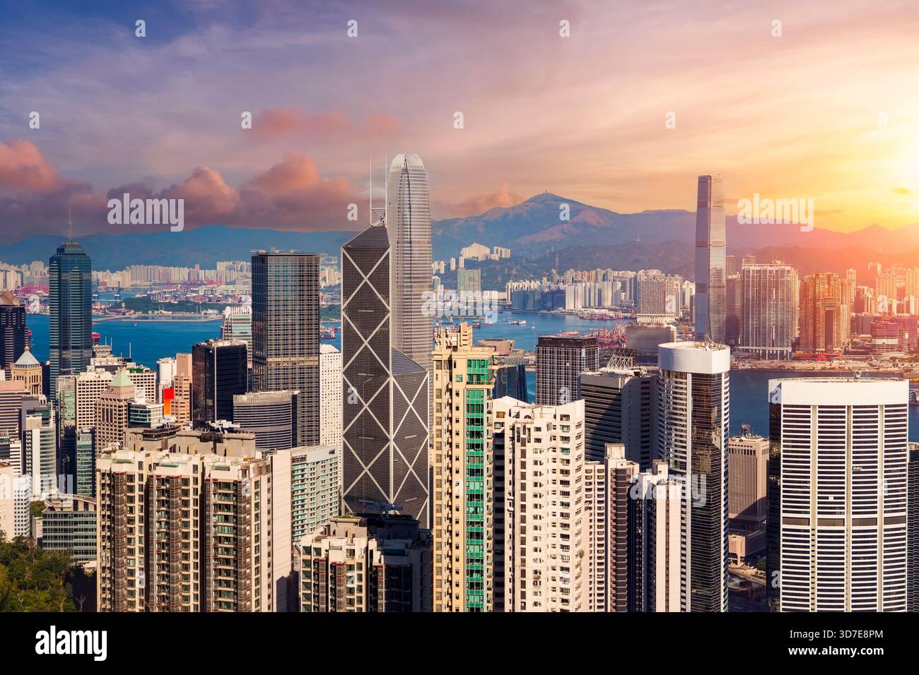 Vista panoramica dello skyline della città dalla cima delle colline alla zona centrale di Hong Kong nelle ore serali con una splendida luce del tramonto e il cielo Foto Stock