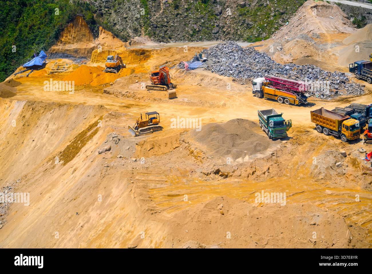 Vista aerea direttamente sopra un dumper industriale o un veicolo in movimento terra con terreno fangoso e tracce di pneumatici nel settore edile su un brownfi Foto Stock